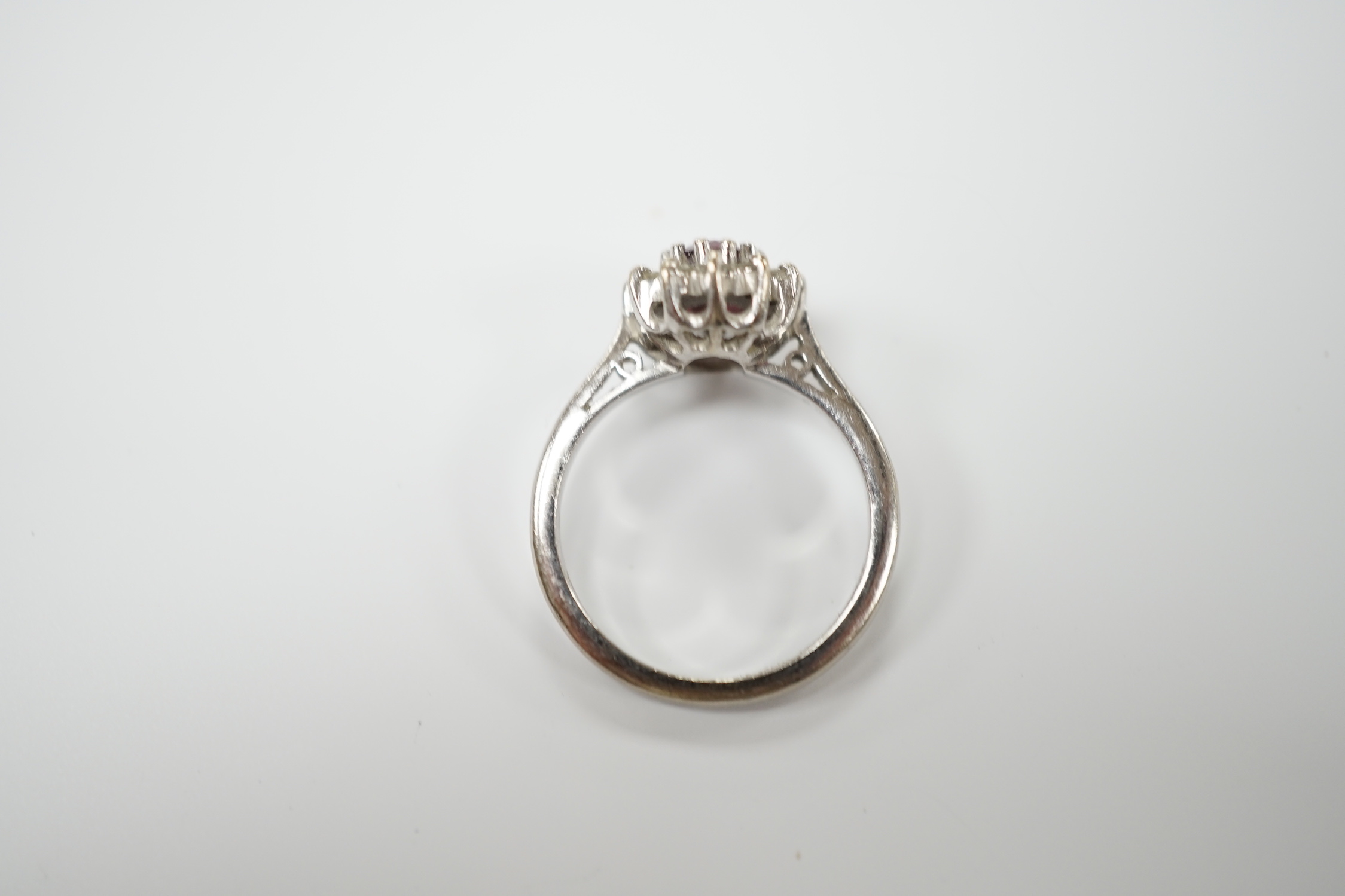 A modern 18ct white gold, ruby and diamond set oval cluster ring, size M/N, gross weight 5.2 grams.